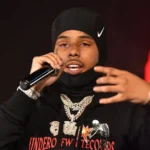 Conceptual image of a golden scale of justice balancing a diamond pendant and a gavel, representing the legal challenges faced by rapper Pooh Shiesty in the Dallas Gucci Mane robbery case.